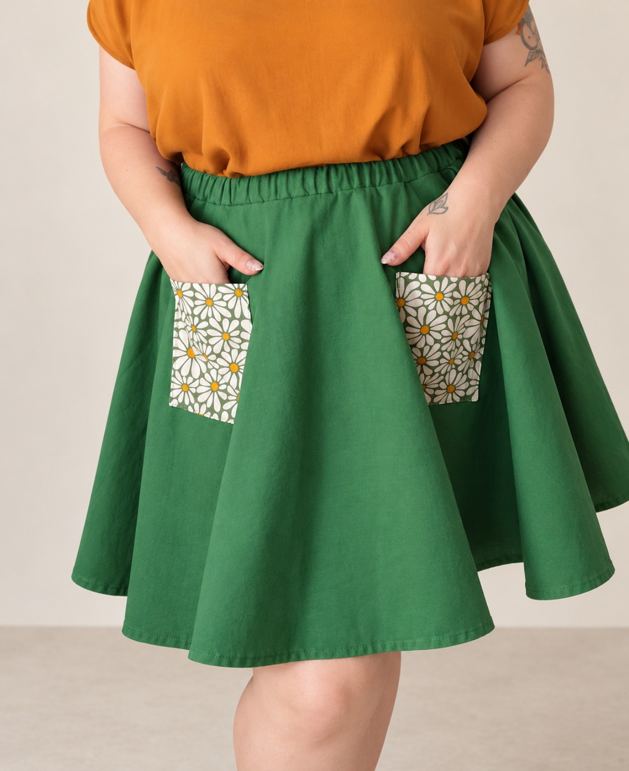 Jupe verte Ça promet ! à ceinture élastique et poches plaquées à fleurs, portée avec un haut ocre